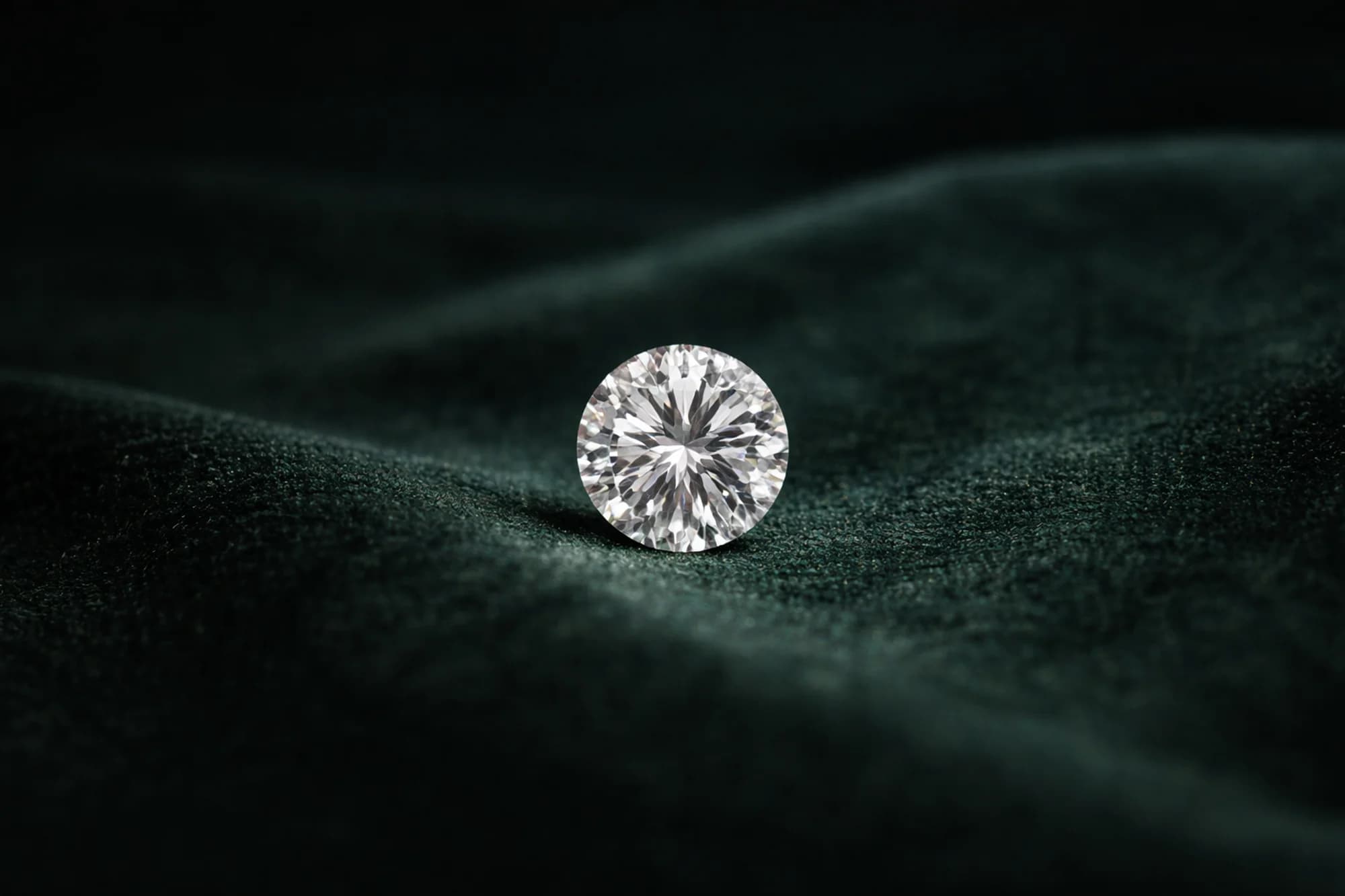 Round brilliant diamond resting on deep emerald green velvet